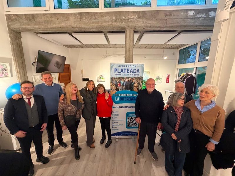 Integrantes de Generación Plateada junto al banner de la organización en un encuentro